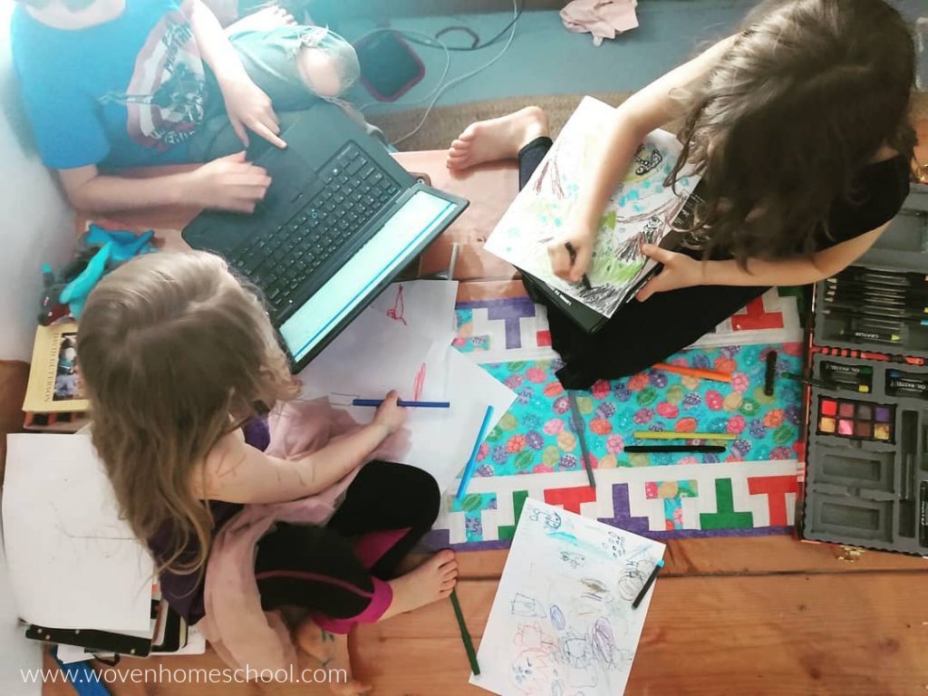 Children coloring and typing at the kitchen table. 